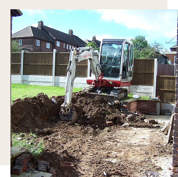 Workman using a mini digger and excavating a hole